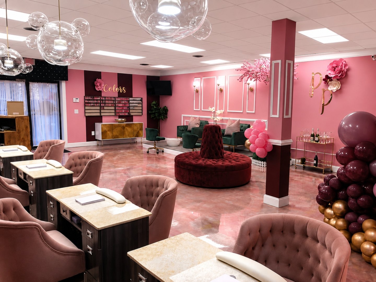 Platinum Pinkyz Salon interior with burgundy ottoman, manicure stations, and glass pendant lighting