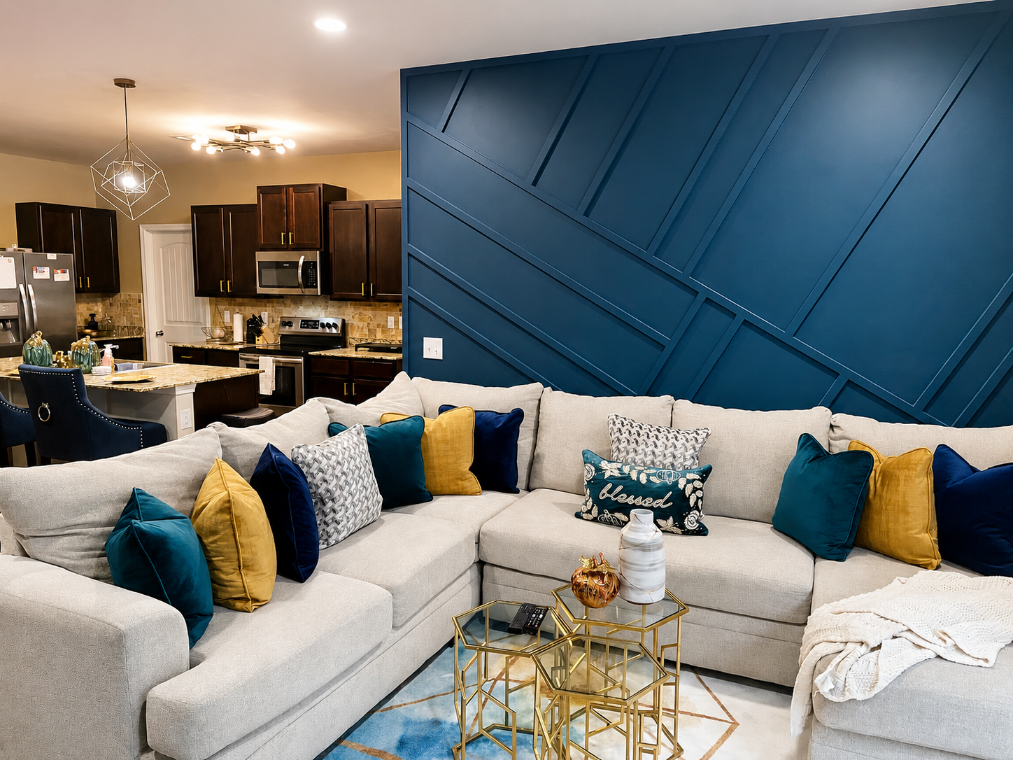 Open-concept living room with navy geometric accent wall and cream sectional