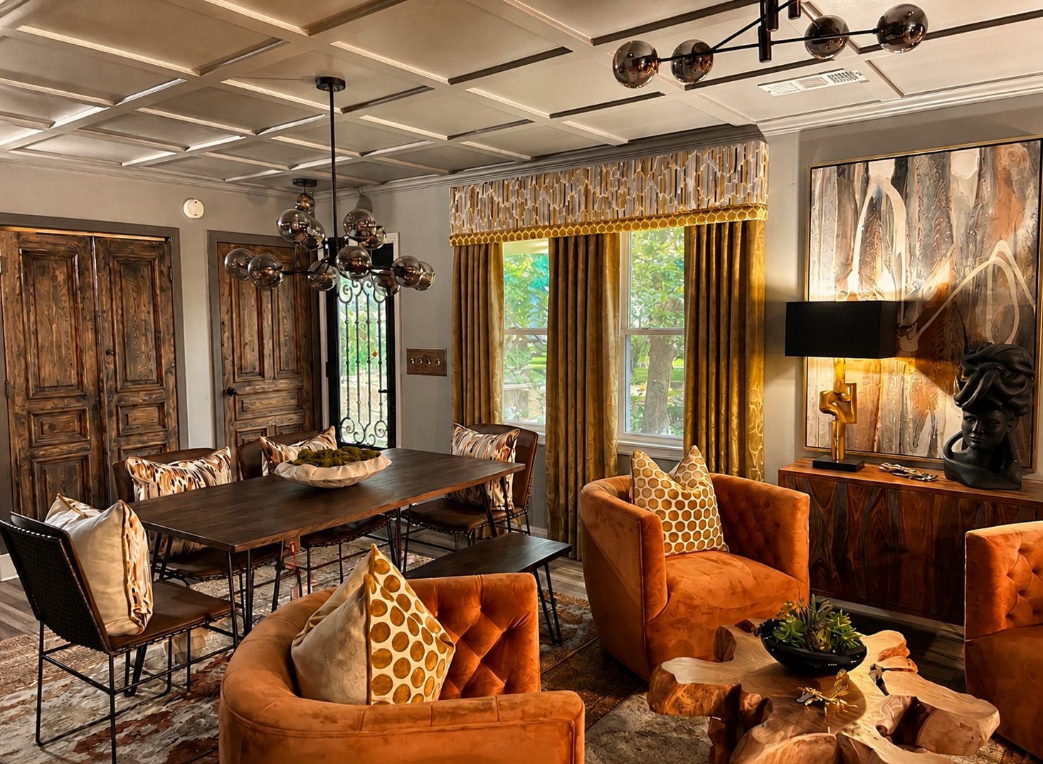 Open-concept living and dining area with coffered ceiling, orange velvet chairs, and sputnik chandelier
